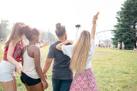 Friends at music festival taking live video to social mediaの写真素材