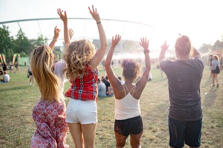 Group of friends jumping at summer music festival