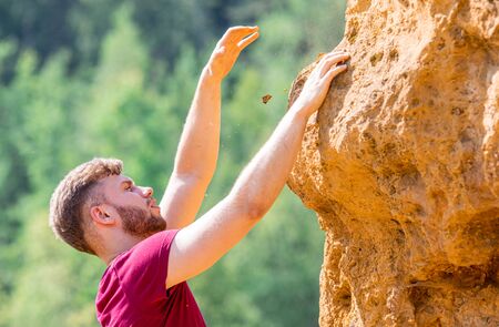 Fit man climbing on rocks obstacles in the boot campの写真素材