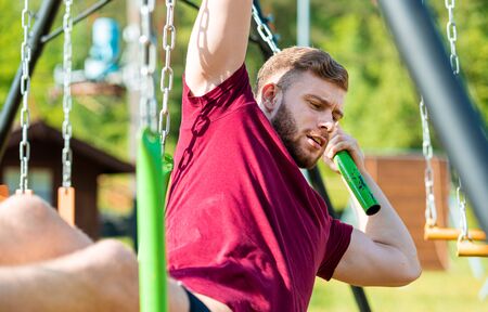 Fit man climbing monkey bars during obstacle course in boot camp