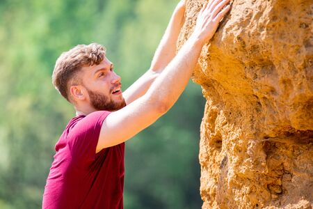 Fit man climbing on rocks obstacles in the boot campの写真素材
