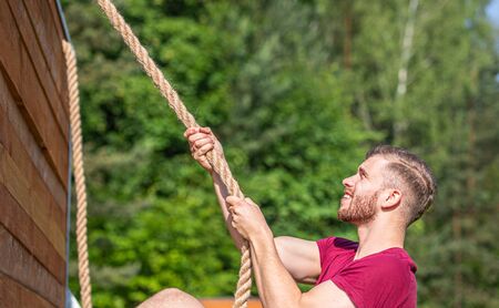 Man overcome barriers by hands during obstacle course in the boot campの写真素材