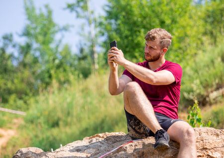 Fit man using smartphone to take a photo during training outdoorの写真素材