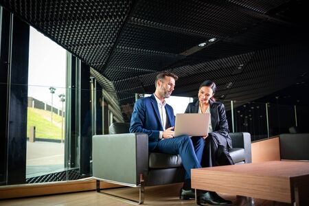 Business people with laptop in modern office building talking about projectの写真素材