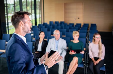 Speaker giving a talk on corporate Business Conference to audience at the conference hallの写真素材