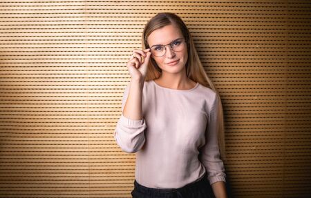 Portrait of pretty young business woman with eyeglasses looking at cameraの写真素材
