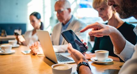 Businessman using smartphone during meeting in cafeの写真素材