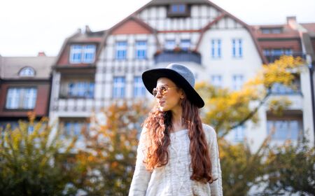 Stylish smiling happy long haired woman walking in city streetの写真素材