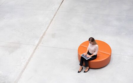 Business woman using laptop sitting alone top view, copy space backgroundの写真素材