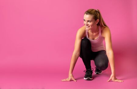 Fit woman on pink background at starting with copy spaceの写真素材