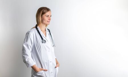 Medical concept of young female doctor in white coat with stethoscope copy spaceの写真素材