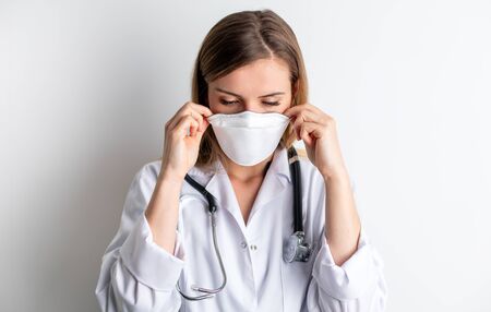 Virus mask female doctor puts on face protection in prevention for coronavirusの写真素材