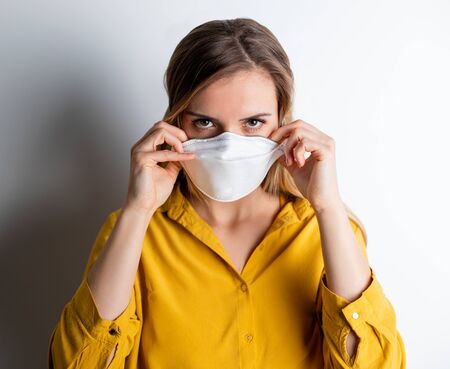 Virus mask woman puts on face protection in prevention for coronavirusの写真素材