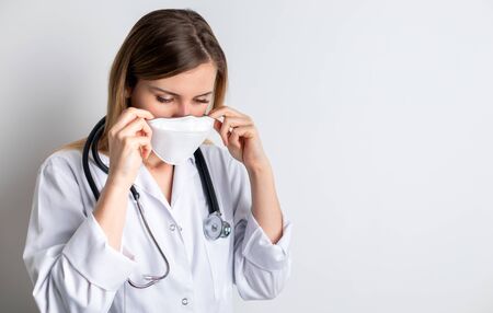Virus mask female doctor puts on face protection in prevention for coronavirusの写真素材