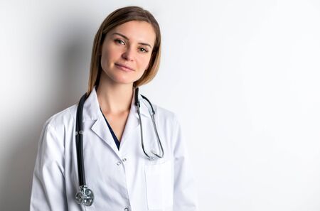 Medical concept of young female doctor in white coat with stethoscope copy spaceの写真素材