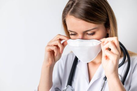 Virus mask female doctor puts on face protection in prevention for coronavirusの写真素材