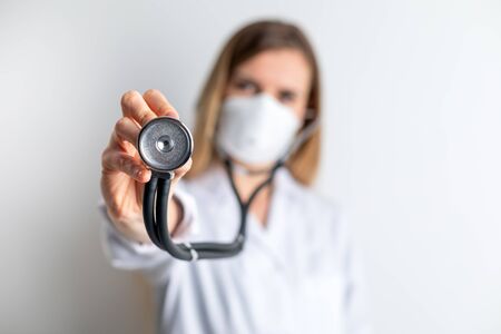 Female doctor with a stethoscope and virus protective mask medical care conceptの写真素材
