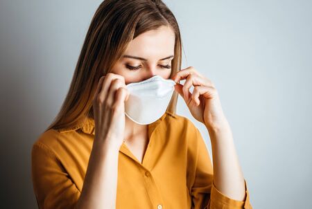 Virus mask woman puts on face protection in prevention for coronavirusの写真素材