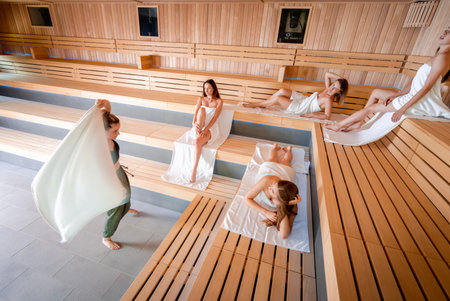 Traditional sauna ritual performed for group of females in spa centerの写真素材