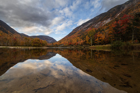 Autumn Landscape with colorful forest and lake in the mountains.