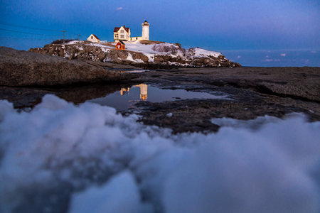 Lighthouse on a rock in the evening.の写真素材