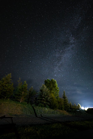 Milky Way in the night sky over the forest. Long exposure photograph.の写真素材