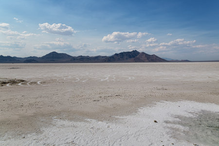 Salt lake in the middle of the desert with mountains in the backgroundの写真素材