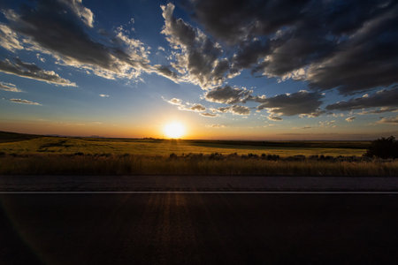 Sunset on the prairie with a road in the foreground.の写真素材