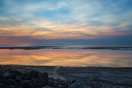 sunset on the sea with clouds and sky reflection in the waterの写真素材