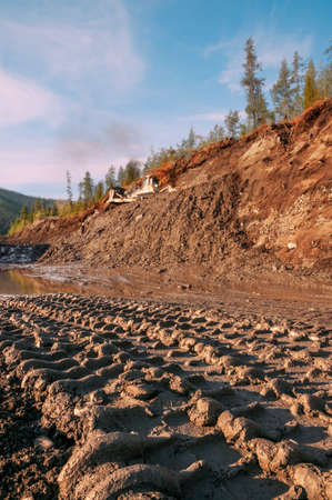 Pattern of a mining truck wheelprint on a wet dirt road in a mountainous area in an industrial area....