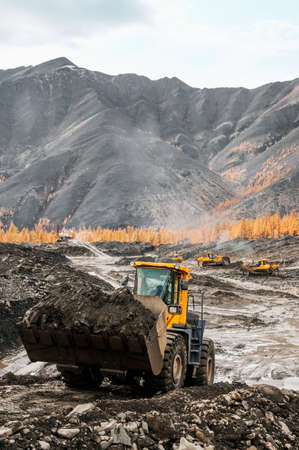 Front-end loader in the mode of transporting mountain soil. Earthworks in mountainous areas.