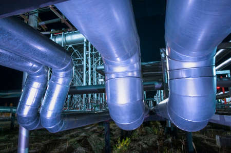 Gate valve on an oil pipe against the background of an oil pumping station