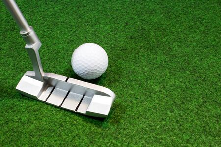 Putter, golf ball and green for the relaxed office life