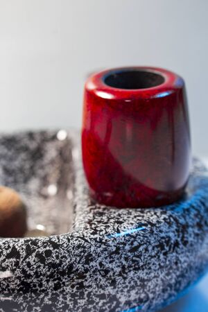 Macro picture ashtray with red pipeの写真素材