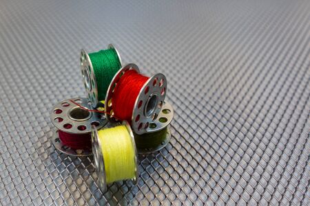 Yarn coils of a sewing machine with different yarn colours