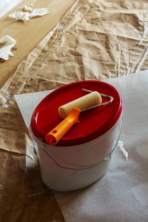 orange handle of the paint roll with single paint roll on the paint bucketの写真素材
