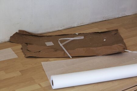new roll of non-woven wallpaper with old paper scraps in the background as protection for the floorの写真素材