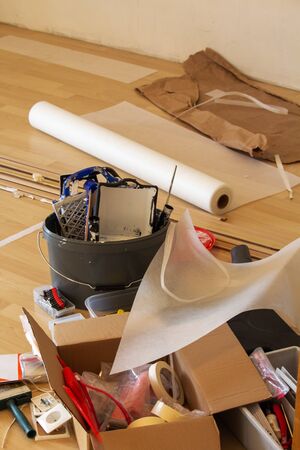 grey paint bucket, in the background, with utensils for painting. In the foreground various toolsの写真素材