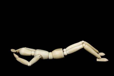 wooden puppet during yoga exercise Ansanas, abdominal muscle exercise, in front of black backgroundの写真素材
