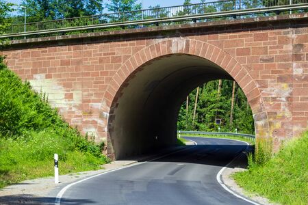 arch of a railway tunnel bordered with sandstonesの写真素材