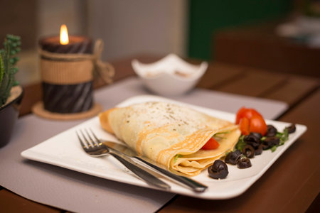 Vegetarian pancakes with vegetables in romantic restaurantの写真素材