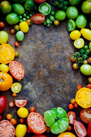 Fresh heirloom tomatoes background, organic produce at a Farmer's market. Tomatoes frame.の写真素材