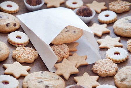Gift in a paper bag - homemade cookies and candies on a brown wooden backgroundの写真素材