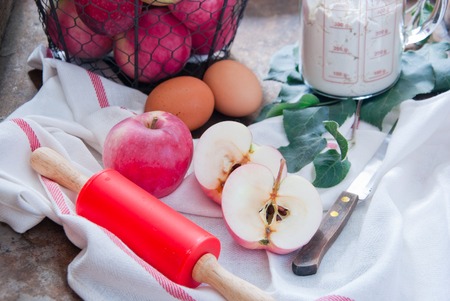 Making Homemade Apple Pie with flour, eggs and rolling pin redの写真素材