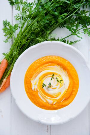 Creamy Organic Carrot Soup on a white wooden backgroundの写真素材