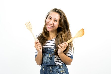 Beautiful smiling girl with kitchen toolsの写真素材