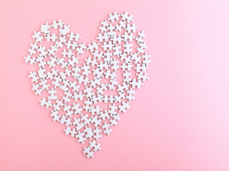 puzzle made heart sharp on pink backgroundの写真素材