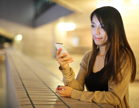 Asian woman using smartphone at night の写真素材