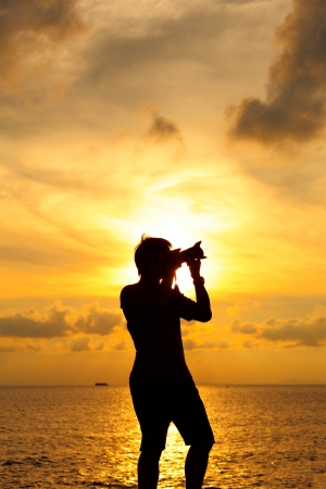 Silhouette photographer at sunsetの写真素材