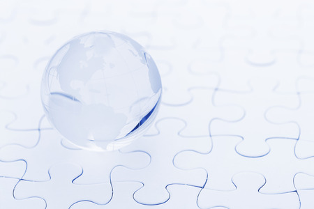 Glass globe ball on puzzleの写真素材